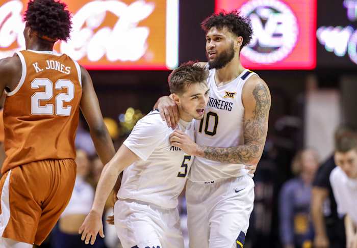 West Virginia Mountaineers guard Jordan McCabe (5) celebrates with West Virginia Mountaineers guard Jermaine Haley (10) after a play during the first half against the Texas Longhorns at WVU Coliseum.